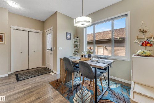 Dining area featuring wood-finish flooring and a large window with white trim - 1514 26 Avenue Nw, Edmonton, AB - Indoor Photo Showing Dining Room