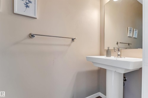 Pedestal sink with chrome faucet, complemented by a wall-mounted mirror - 1514 26 Avenue Nw, Edmonton, AB - Indoor Photo Showing Other Room