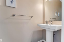 Pedestal sink with chrome faucet, complemented by a wall-mounted mirror - 