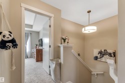 Open doorway leading to a room with light-colored carpet and a window with drapes - 