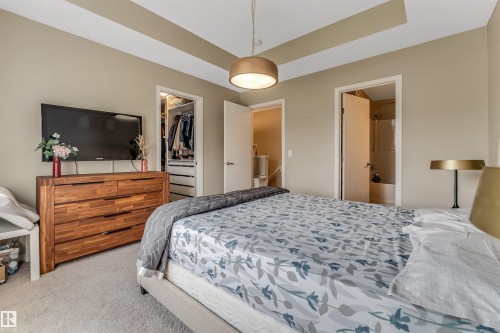 Bedroom with a tray ceiling and a contemporary pendant light fixture - 1514 26 Avenue Nw, Edmonton, AB - Indoor Photo Showing Bedroom