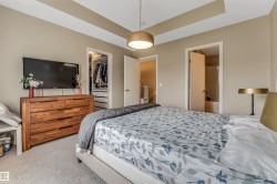 Bedroom with a tray ceiling and a contemporary pendant light fixture - 