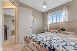 Carpeted bedroom with a large window and a white pendant light fixture - 