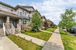 Modern townhome exterior featuring multi-toned siding, stone accents, and a covered porch entry - 
