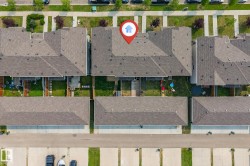 Aerial perspective of a multi-unit property with composite shingle roofing and private rear yards - 