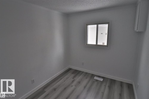 Wood-finish flooring, white walls, and a window with a white frame - 98 Willow Park Estates, Leduc, AB 