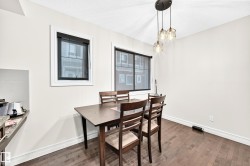 Wood-finish flooring, white walls, and a multi-light pendant fixture - 