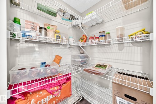 Spacious walk-in pantry featuring multiple levels of wire shelving for storage - #146 655 Tamarack Rd Nw, Edmonton, AB 