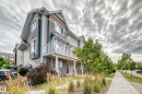 Multi-level exterior with mixed siding, upper-level balcony with white railings, and ground-level entryway with stone-clad columns - #146 655 Tamarack Rd Nw, Edmonton, AB 