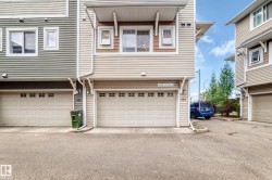 Exterior featuring horizontal siding, white-framed windows, and a two-car garage - 