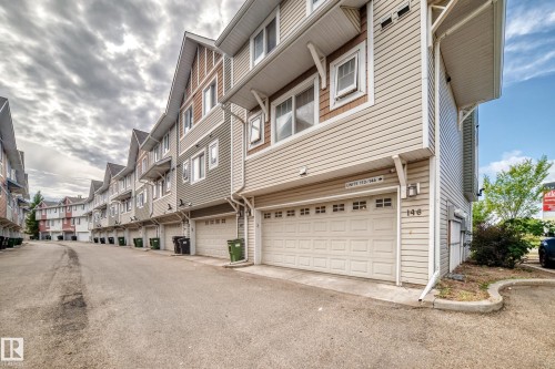 Siding exterior featuring a garage, white trim, and a gabled roofline - #146 655 Tamarack Rd Nw, Edmonton, AB 