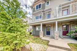 Multi-level exterior with stone accents, covered entryways, and upper-level balconies featuring white railings - 