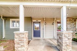 Covered entry with stone-clad columns and a blue paneled door - 
