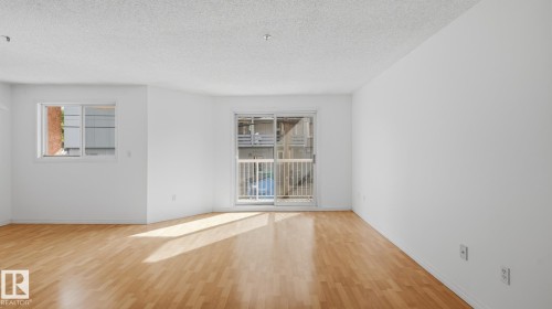Wood-finish flooring with white walls and a textured ceiling - #107 10153 117 St Nw, Edmonton, AB 