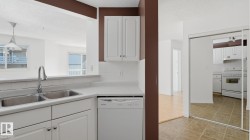 Kitchen featuring a double stainless steel sink, white dishwasher, white cabinetry, and tiled flooring - 
