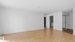 Hardwood-style flooring throughout, white walls, and a recessed laundry area - 