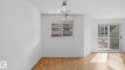 Wood-finish flooring, white walls, overhead ceiling light fixture, sliding glass door with balcony access, and a window - 
