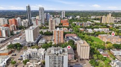 Aerial perspective of a dense urban environment with a variety of multi-story buildings and green spaces - 