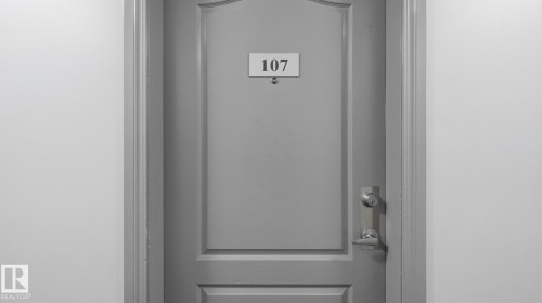 Paneled door with a polished chrome handle and a deadbolt - #107 10153 117 St Nw, Edmonton, AB 