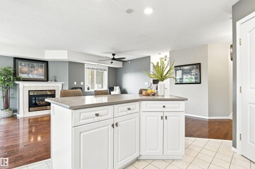 Kitchen island with white cabinetry and a light-toned countertop - #432 6703 172 St Nw, Edmonton, AB 