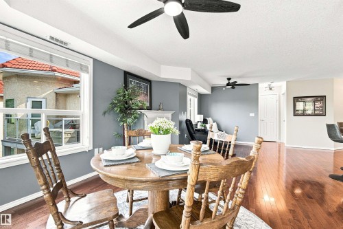 Bright dining area featuring wood-finish flooring, a window with exterior property views, and a ceiling fan - #432 6703 172 St Nw, Edmonton, AB 
