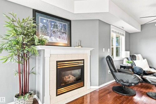 Corner fireplace with a tile surround and white mantel - #432 6703 172 St Nw, Edmonton, AB 