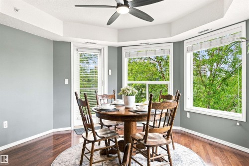 Hardwood-finish flooring, recessed ceiling, ceiling fan, multiple windows with blinds, and a built-in door leading to the exterior - #432 6703 172 St Nw, Edmonton, AB 