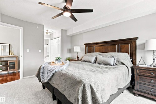 Carpet flooring with a wood-finish headboard and matching nightstand - #432 6703 172 St Nw, Edmonton, AB 