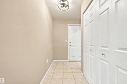Entryway featuring tile flooring, a paneled door, and bi-fold closet doors - 