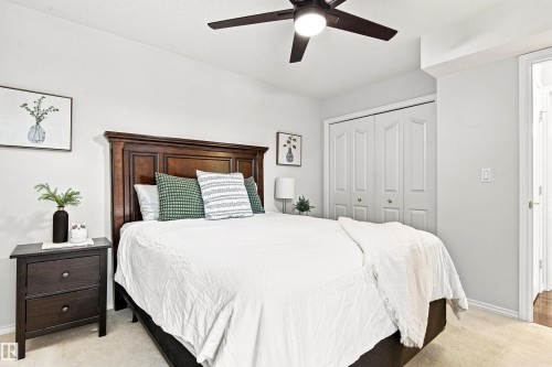 Tray ceiling with a ceiling fan, light-toned carpeting, bi-fold closet doors, and light wall paint - #432 6703 172 St Nw, Edmonton, AB 
