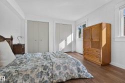 Wood-finish flooring with white trim, two white bi-fold closets, and multiple windows - 