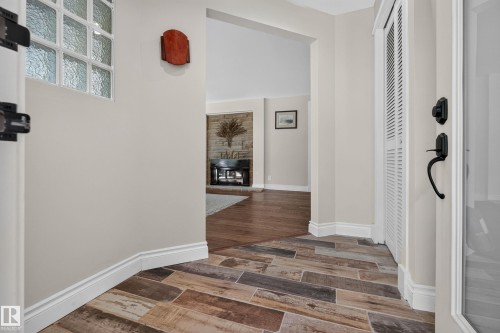 Wood-look tile flooring in a chevron pattern, glass block window, louvered bi-fold door, and black hardware on the entry door - 11603 72 Avenue Nw, Edmonton, AB 