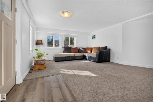 Spacious interior with neutral carpeting and wood-finish flooring - 11603 72 Avenue Nw, Edmonton, AB 