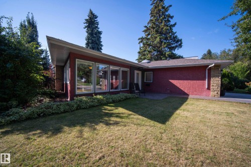 Angled roofline, red stucco exterior, large windows, stone column accent, and an exterior patio - 11603 72 Avenue Nw, Edmonton, AB 