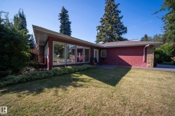 Angled roofline, red stucco exterior, large windows, stone column accent, and an exterior patio - 