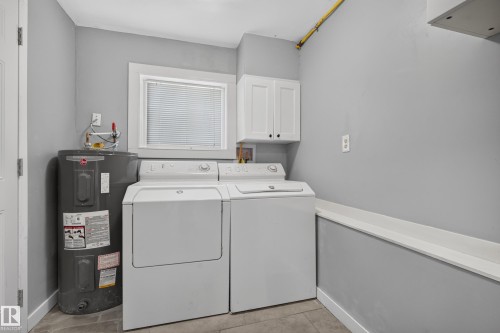 Utility area featuring a window, wall-mounted cabinetry, and tile flooring - 11603 72 Avenue Nw, Edmonton, AB 