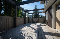 Expansive wood-finish decking with a privacy fence, an overhead trellis structure, and direct exterior access - 