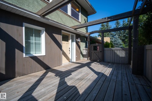 Expansive wooden deck featuring an integrated pergola structure, exterior siding, and a private wooden gate - 11603 72 Avenue Nw, Edmonton, AB 
