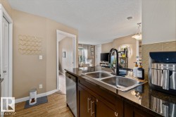 Kitchen island with a double stainless steel sink, black faucet, and dark countertops - 