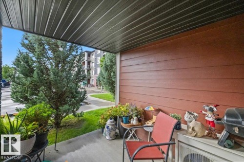 Covered patio with a slatted ceiling, brown horizontal siding, and concrete flooring - #120 5370 Chappelle Rd Sw, Edmonton, AB 