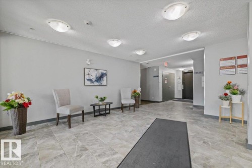 Spacious common area featuring neutral wall tones, recessed lighting, and tile flooring - #120 5370 Chappelle Rd Sw, Edmonton, AB 