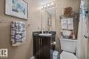 Vanity with dark wood-finish cabinetry, countertop, and an integrated basin - #120 5370 Chappelle Rd Sw, Edmonton, AB 