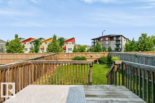 Expansive backyard featuring a wood deck with railings, a lush green lawn, and a perimeter wooden fence - 3496 Weidle Way Sw, Edmonton, AB - Outdoor With Deck Patio Veranda