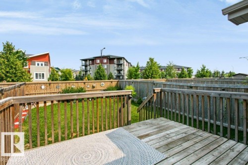 Wood deck with railing and stairs overlooking a fenced yard with green lawn - 3496 Weidle Way Sw, Edmonton, AB - Outdoor With Deck Patio Veranda With Exterior