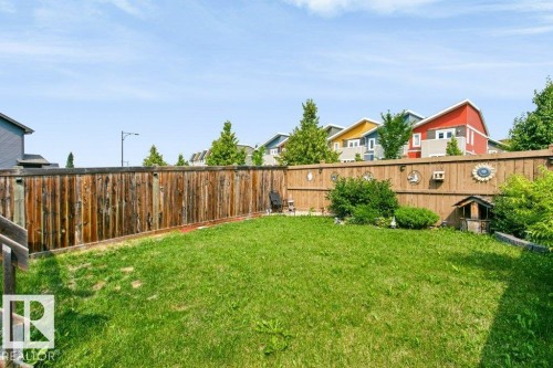 Expansive backyard featuring a manicured lawn, a full-height wood fence, and mature perimeter shrubs - 3496 Weidle Way Sw, Edmonton, AB - Outdoor