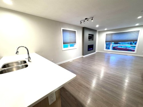 White countertop with integrated double basin sink and gooseneck faucet - 12046 89 Street Nw, Edmonton, AB 