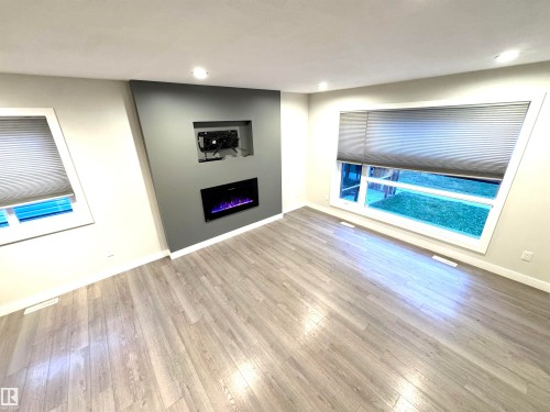 Wood-finish flooring, recessed lighting, and large windows with cellular shades - 12046 89 Street Nw, Edmonton, AB 