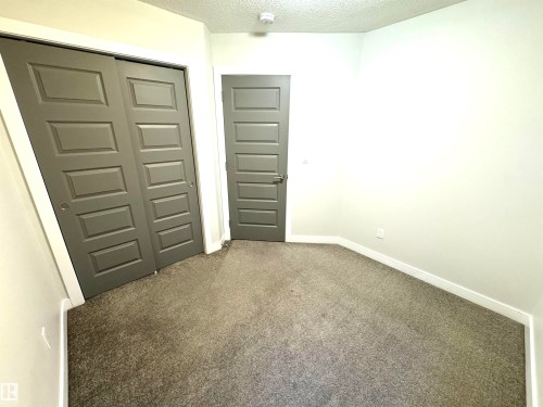 Neutral wall color, wall-to-wall carpeting, gray paneled doors, and white trim - 12046 89 Street Nw, Edmonton, AB 