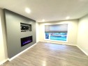 Recessed electric fireplace with a media niche, wood-finish flooring, and recessed ceiling lighting - 12046 89 Street Nw, Edmonton, AB 