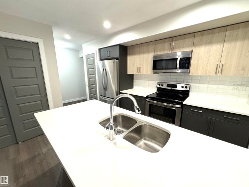 White countertop with a double basin stainless steel sink - 12046 89 Street Nw, Edmonton, AB 